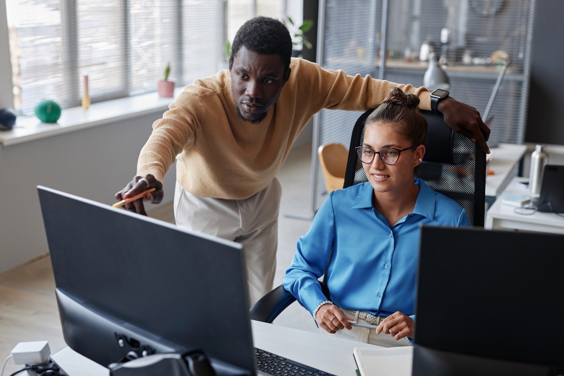 Image of two colleagues reviewing data on computer screen