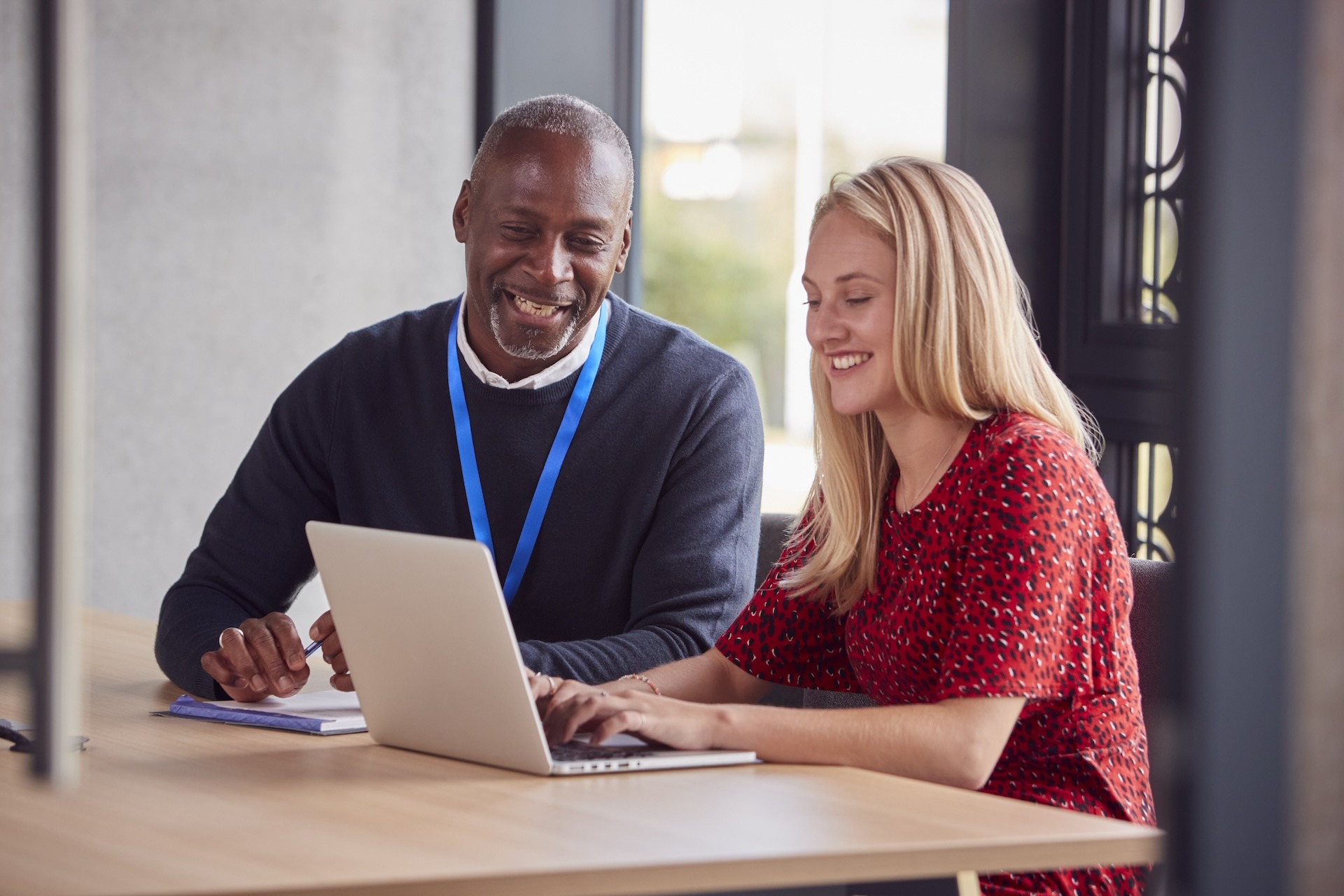 Image of IT support engineer helping coworker with her laptop