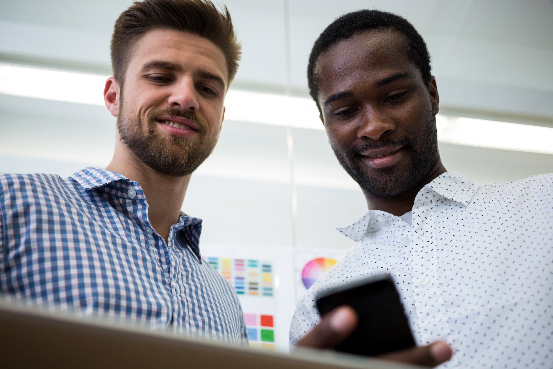 Image of two colleagues reviewing mobile configuration on devices