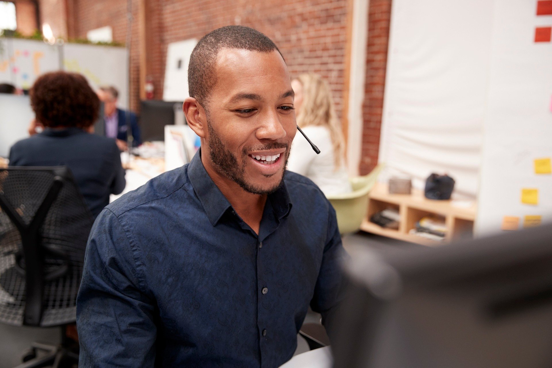 Image of male support agent helping coworkers via the phone