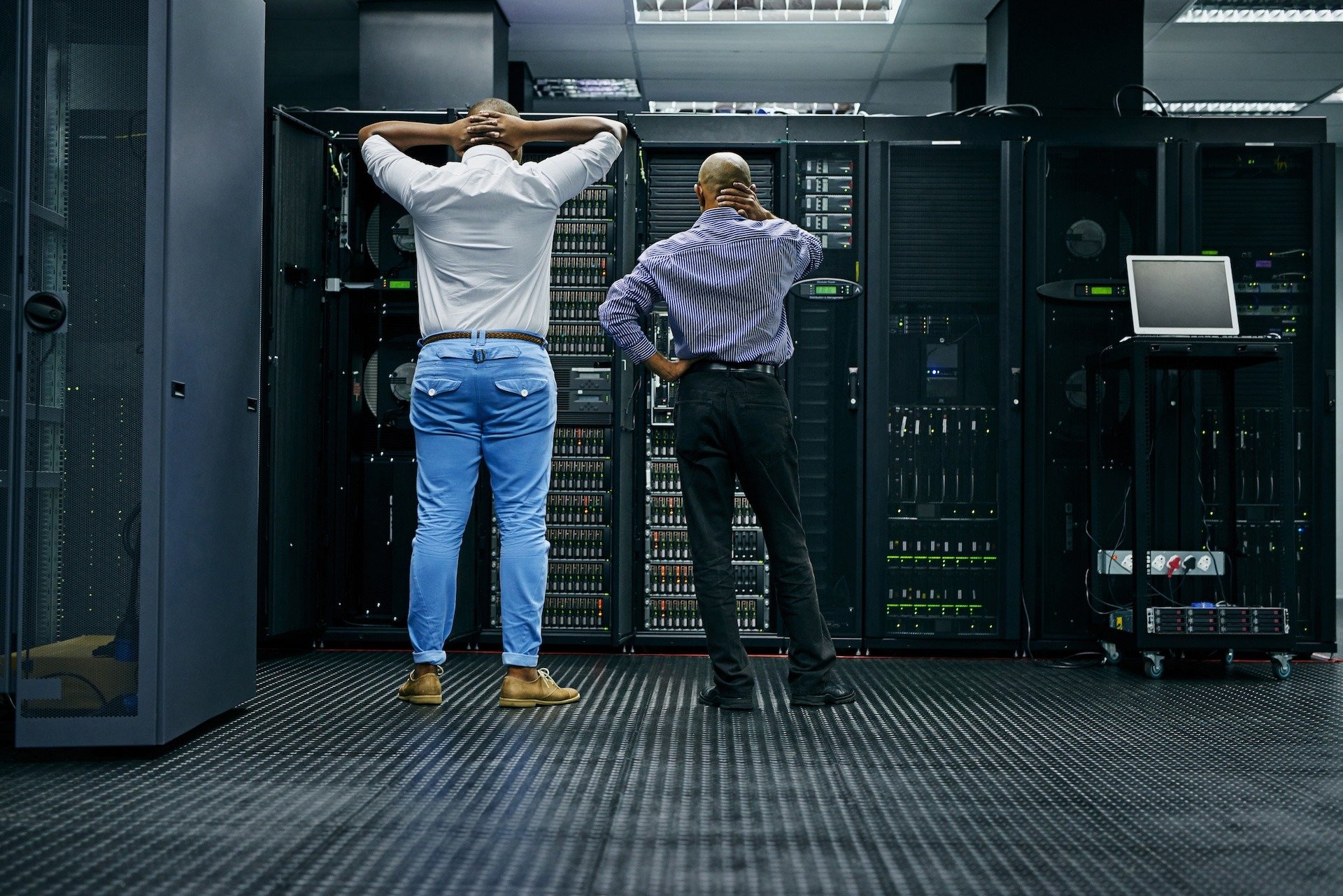 Image of two IT engineers staring at a server rack contemplating what to do after an IT disaster